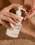 Salt & Stone Bergamot & Hinoki Body Lotion - Closeup of model dispensing product into hand