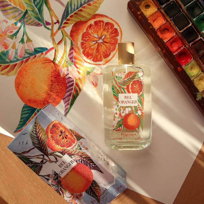 Fragonard Parfumeur Bel Oranger Eau de Toilette - Life style photo of perfume bottle, packaging, and paint palette on watercolor painting of oranges