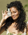 Roz Saint Lucia Styling Oil  - Model shown holding product next to face