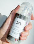 R+Co Grasp Intense Hold Shaping Balm - Product shown in models hand
