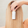 Innersense Organic Beauty Hair Renew Daily Active Serum - product shown being held next to women's head.