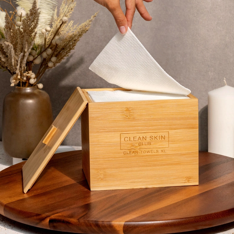 Clean Skin Club Luxe Bamboo Box with Cover - Product displayed on wood table, filled with towels