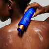 Augustinus Bader The Body Cleanser - Model shown dispensing product onto back
