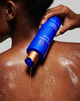 Augustinus Bader The Body Cleanser - Model shown dispensing product onto back