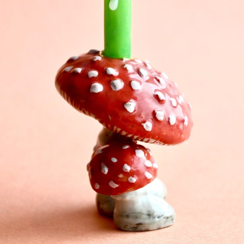Camp Hollow Mushroom Cake Topper - Closeup of product with candle in holder