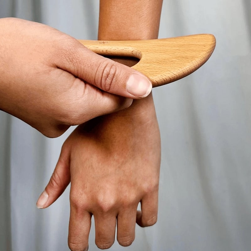 Daily Concepts Wooden Body Gua Sha Tool - Closeup of model using product on arm