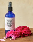 La Ferme de l'Ours Damask Rose Flower Water - Beauty shot, product shown on wood table with rose petals