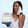 Clean Skin Club Clean Towels XL Supreme - model holding towel to face and holding towel packaging