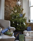 Bamford Christmas Star Gift - Blue - Beauty shot of product with Christmas tree