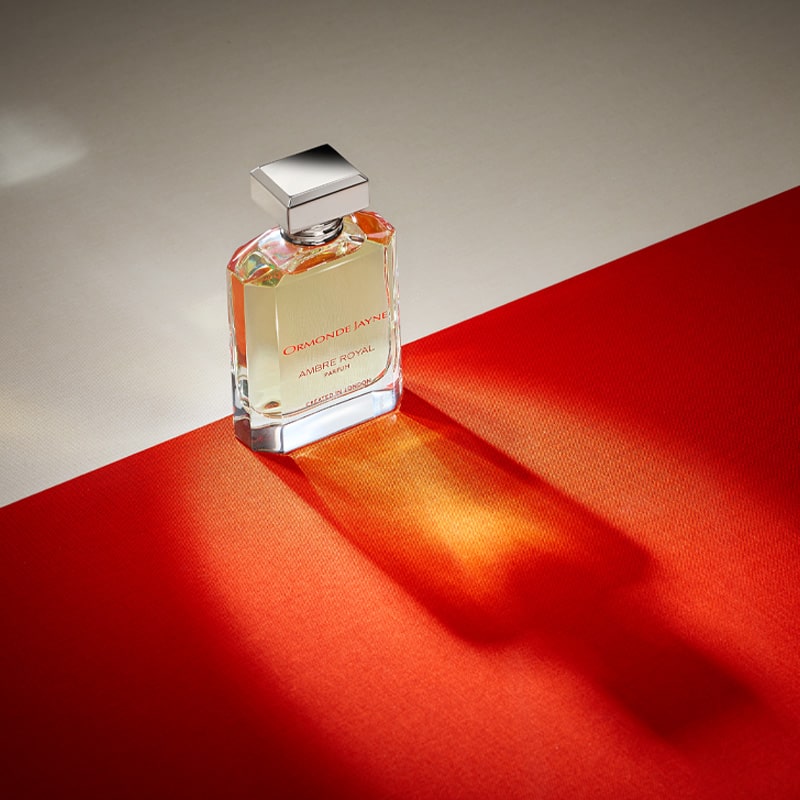 Ormonde Jayne Ambre Royal Eau de Parfum - bottle on red fabric casting shadow
