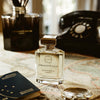 Ormonde Jayne Montabaco Intensivo Eau de Parfum - lifestyle shot of perfume bottle, glasses, phone on a map