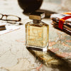 Ormonde Jayne Nawab of Oudh Intensivo Eau de Parfum - lifestyle photo of perfume bottle, glasses, passports, on map