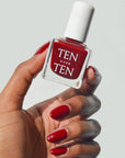 Tenoverten Nail Polish - Carmine - model holding nail polish bottle