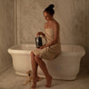 Tenoverten The Recovery - model holding product sitting on bath tub in a towel