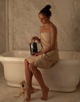 Tenoverten The Recovery - model holding product sitting on bath tub in a towel