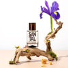 Solinotes Sandalwood Eau de Parfum - lifestyle photo of bottle on branch with flowers