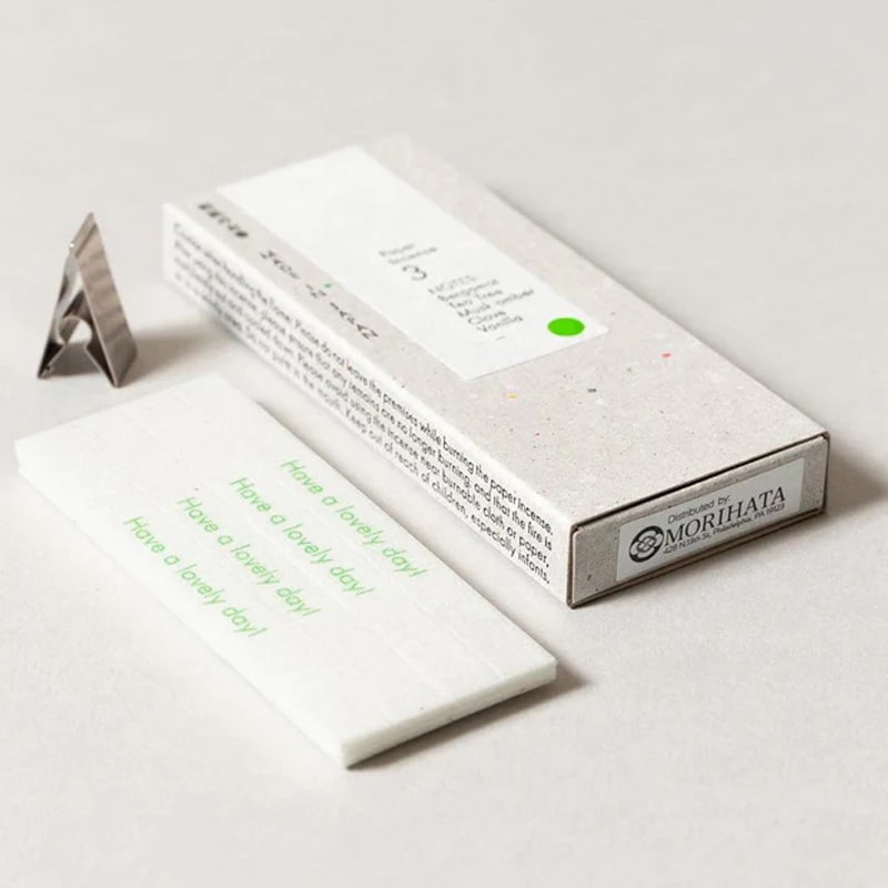 Kunjudo Washi Paper Incense Strips - Deep Citrus - incense papers, metal clip, and packaging box on table