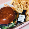 Versatile Paris God Bless Cola Extrait de Parfum shown in a tray with French Fries and a Hamburger