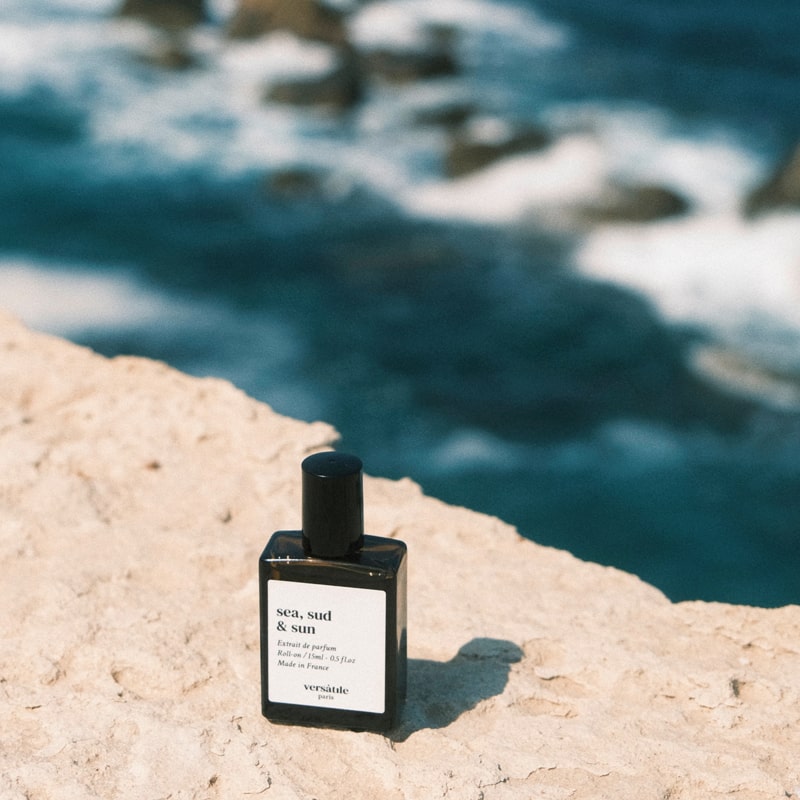 Versatile Paris Sea, Sud &amp; Sun (Sea, South &amp; Sun) Extrait de Parfum shown on sand with ocean in background