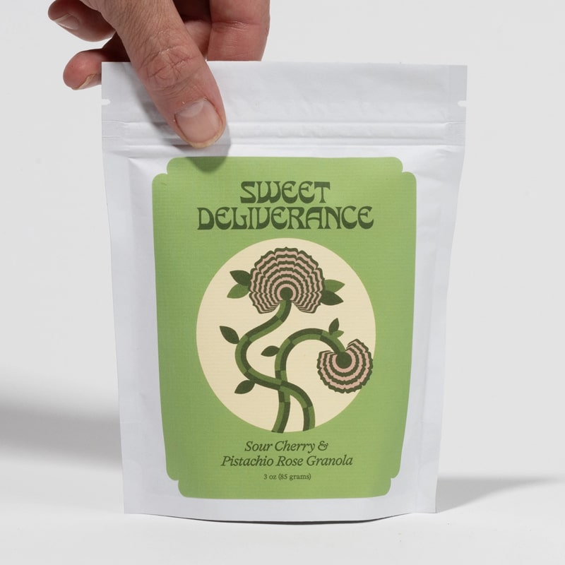 Sweet Deliverance Sour Cherry &amp; Pistachio Rose Granola (3 oz)  - Product shown in models hand