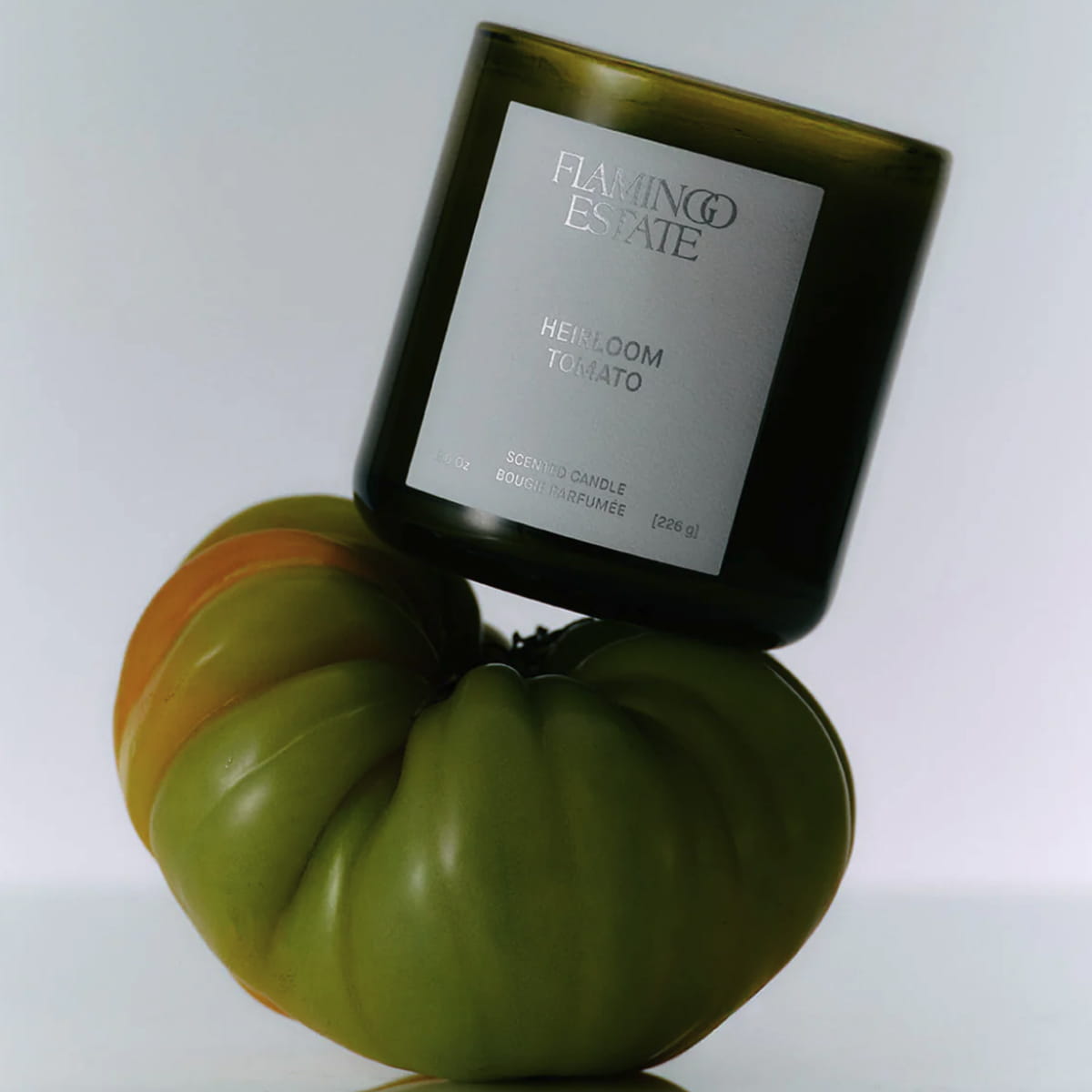 Flamingo Estate Roma Heirloom Tomato Candle (226 g) - product shown on top of tomato.