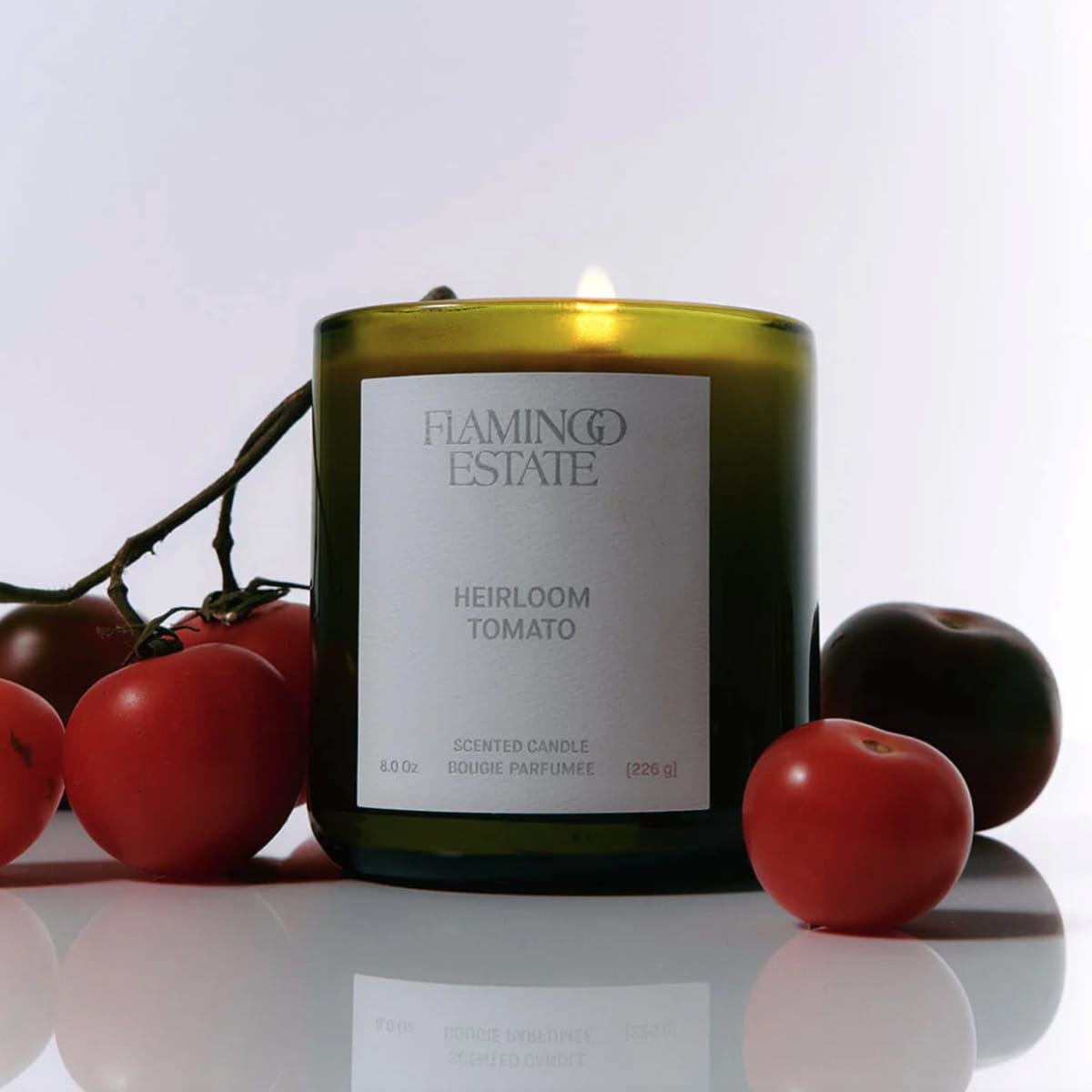 Flamingo Estate Roma Heirloom Tomato Candle (226 g) - product shown with tomatoes around it.