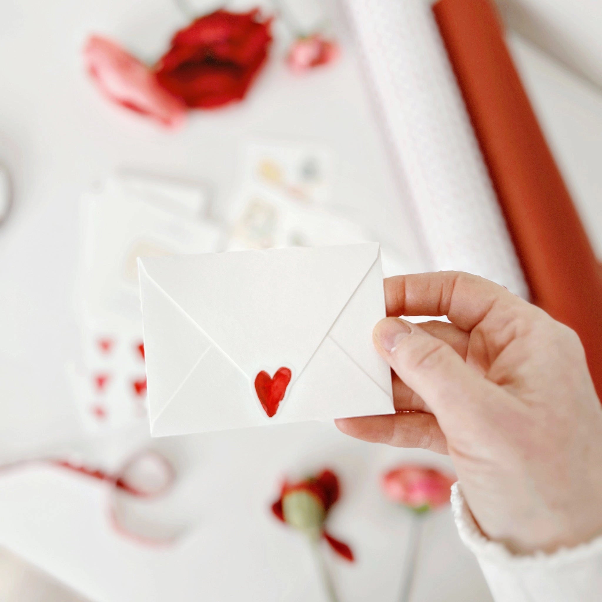 Hand holding an Emily Lex Studio Mini Valentines Day Card white envelope with a red heart