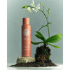 Roz Root Lift Spray- Product shown next to flower