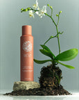Roz Root Lift Spray- Product shown next to flower