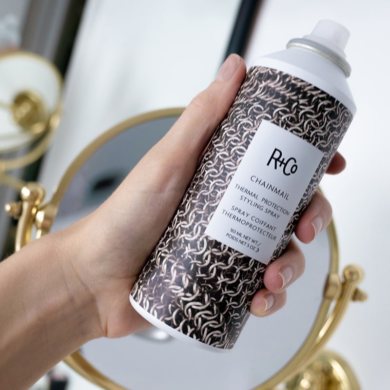 R+Co Chainmail Thermal Protection Styling Spray - Product shown in models hand