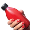 Close up of model wearing Kure Bazaar Nail Lacquer - Spicy Vvee holding bottle