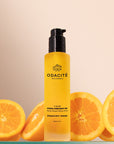 Odacite C-Glow Hydra-Firm Body Oil - Beauty shot, product shown with oranges