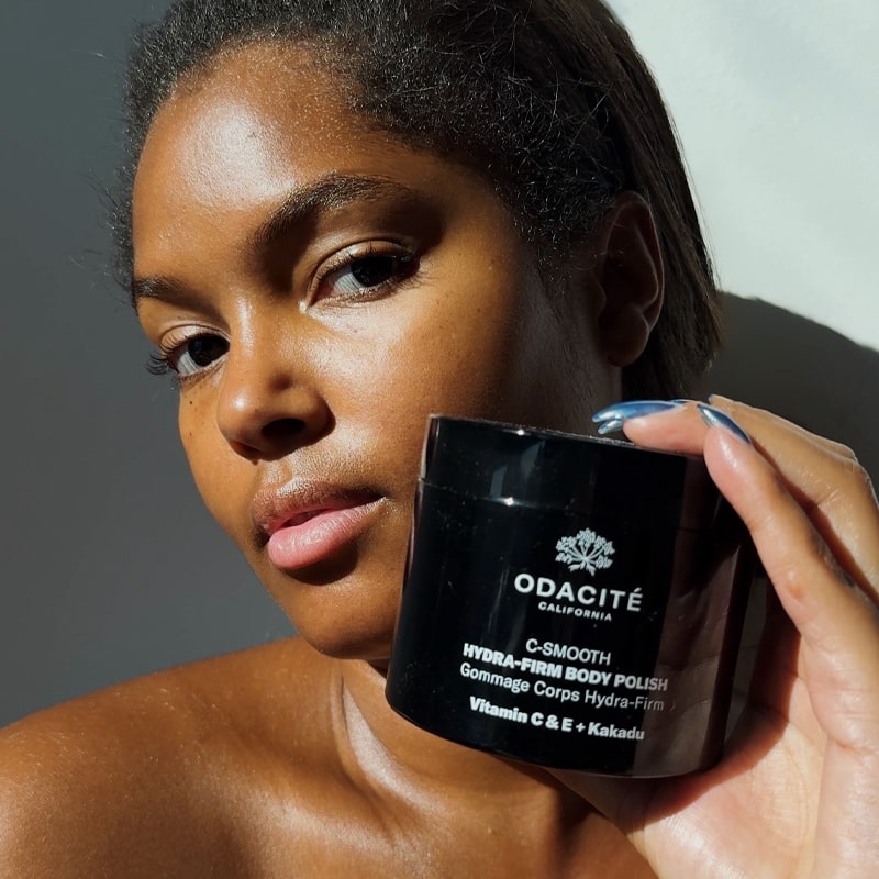 Odacite C-Smooth Hydra-Firm Body Polish - Model shown holding product next to face