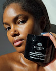 Odacite C-Smooth Hydra-Firm Body Polish - Model shown holding product next to face (227 g)