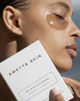 Ametta Skin Care Red Wine Eye Masks- Model shown holding box next to face