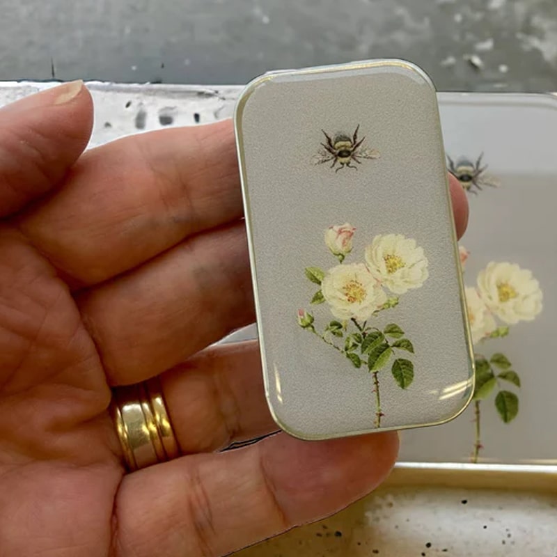 Close up of model holding Firefly Notes Bee and Rose Notions Tin - Small to show size/scale of tin