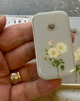 Close up of model holding Firefly Notes Bee and Rose Notions Tin - Small to show size/scale of tin