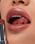 Kosas Wet Stick Moisturizing Lip Shine - Tropic Bliss - Closeup of model holding product next to lips