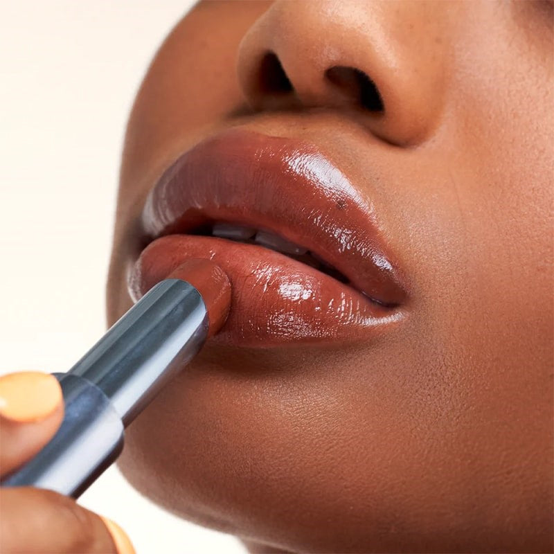 Kosas Wet Stick Moisturizing Lip Shine - Sunset Simmer - Closeup of model applying product