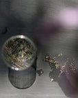 Leaves and Flowers Serenitas  Loose Leaf Tea - loose leaf tea spread out on table and in glass of water