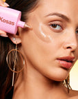 Kosas DreamBeam Sunlit Comfy Smooth Sunscreen SPF 40 - Model shown applying product to face