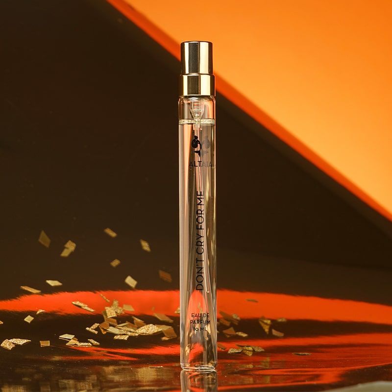 ALTAIA Don’t Cry for Me Eau de Parfum Travel Size - product shown with gold flakes in front of orange background