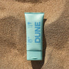 DUNE Suncare The Mineral Melt - Product shown on sand