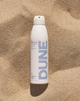 DUNE Suncare The Sporto Spray - Product shown in sand