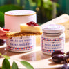 Confiture Parisienne Nuits Saint Georges Jelly - Jelly shown on cheese and cracker held by hand outdoors with grapes