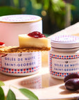 Confiture Parisienne Nuits Saint Georges Jelly - Jelly shown on cheese and cracker held by hand outdoors with grapes