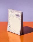 Negative Space Floral Cat - Risograph A2 Notepad - notepad standing upright on desk