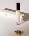 Orchid + Ash Idyll Perfume Travel Spray - Jasmine Incense + Vanilla - product shown next to packaging and earrings
