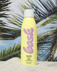 Bask Sunscreen SPF 50 Non-Aerosol Spray Sunscreen - product shown in sand in front of palm trees