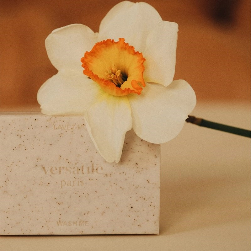 Versatile Paris Cleansing Exfoliating Solid Bar- Product shown with flower
